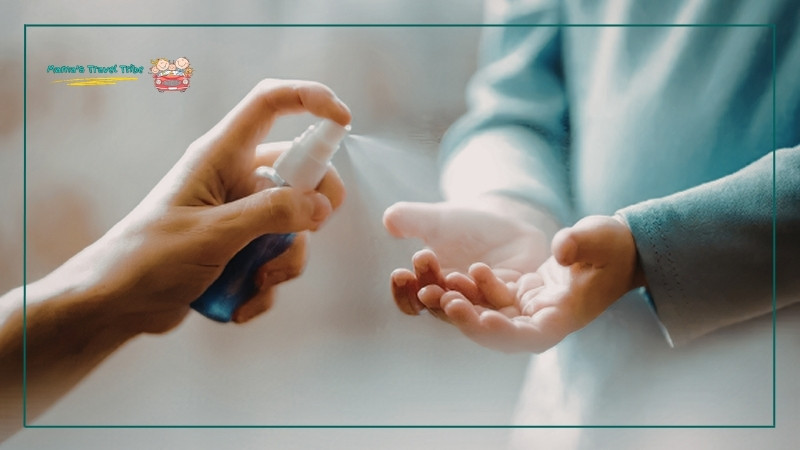 mom spraying hand sanitizer on a child's hand. flying with an infant on lap