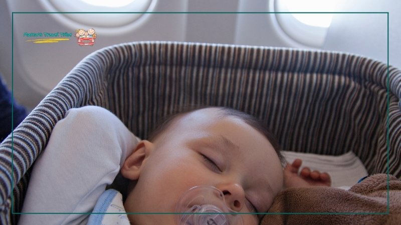 baby sleeping in bassinet in airplane. Prepare for flight- How to Fly With a Newborn