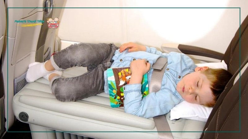 child sleeping on an inflatable mattress in airplane. Flyaway kids bed on airplane. how to make a bed on a plane