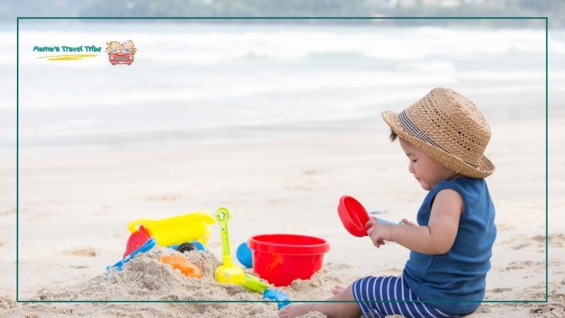 baby playing on the beach with sand toys. toddler beach essentials