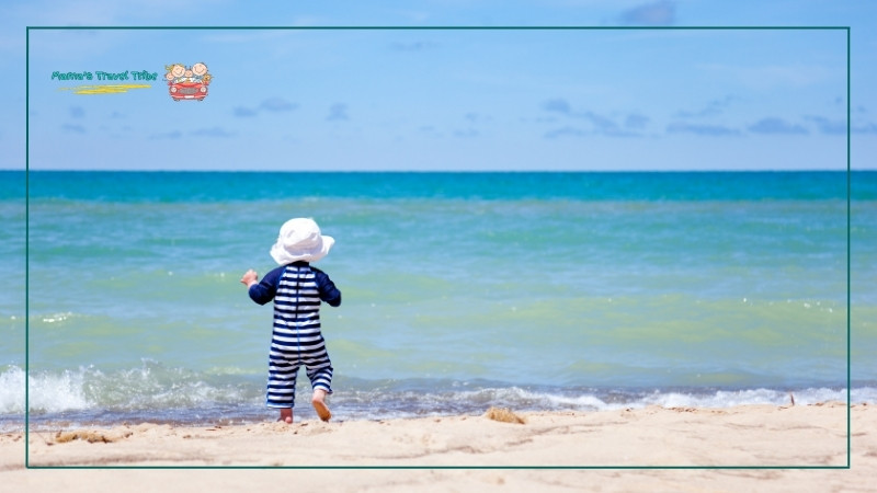 baby on beach with fully covered clothes. toddler beach essentials