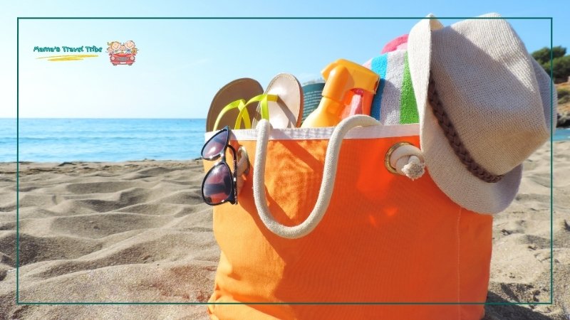 toddler beach essentials. beach bag on beach with essentials.