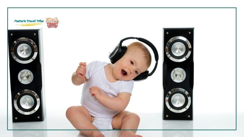 baby dancing with headphones on ears with 2 speakers in the background. Do Babies Need Headphones on Planes