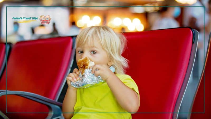  baby eating snack at airport. What Do Kids Need to Fly?