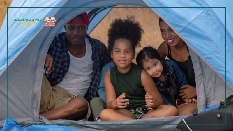 family of 4 in a tent, camping outside. mixed ethnicity. Trips and Activities by Age: Where to Go With Babies, Toddlers, and Preschoolers. best trips with toddelrs. 