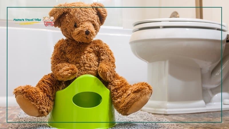 Teddy bear sitting on a portable potty. Diapering, potty, and cleanup essentials. The Ultimate Family Travel Packing List for Babies, Toddlers, and Preschoolers