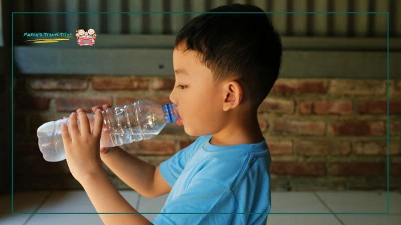 child drinking water from bottle. Heat, sun, and dehydration problems usually build slowly, then hit all at once. Family Travel Safety Guide: Practical Safety Tips for Babies, Toddlers, and Young Kids.